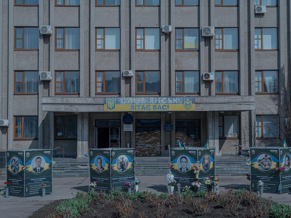 The Alley of Memory memorial sits in front of the Sloviansk City Administration building. A sign at the entrance reads, 