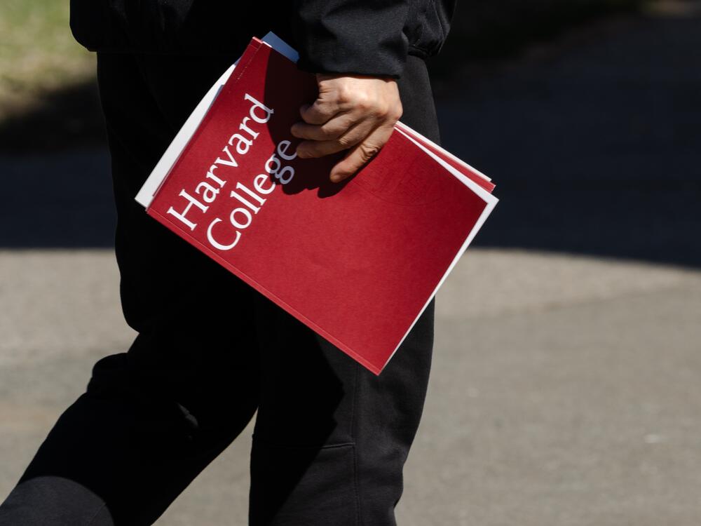 A person holds a Harvard College folder during a tour at Harvard University on April 17 in Cambridge, Mass.