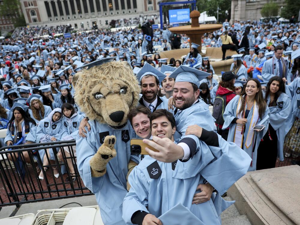 Students pose with a person dressed as Roar-ee the Lion mascot, before the Commencement Ceremony at Columbia University in New York on May 21.