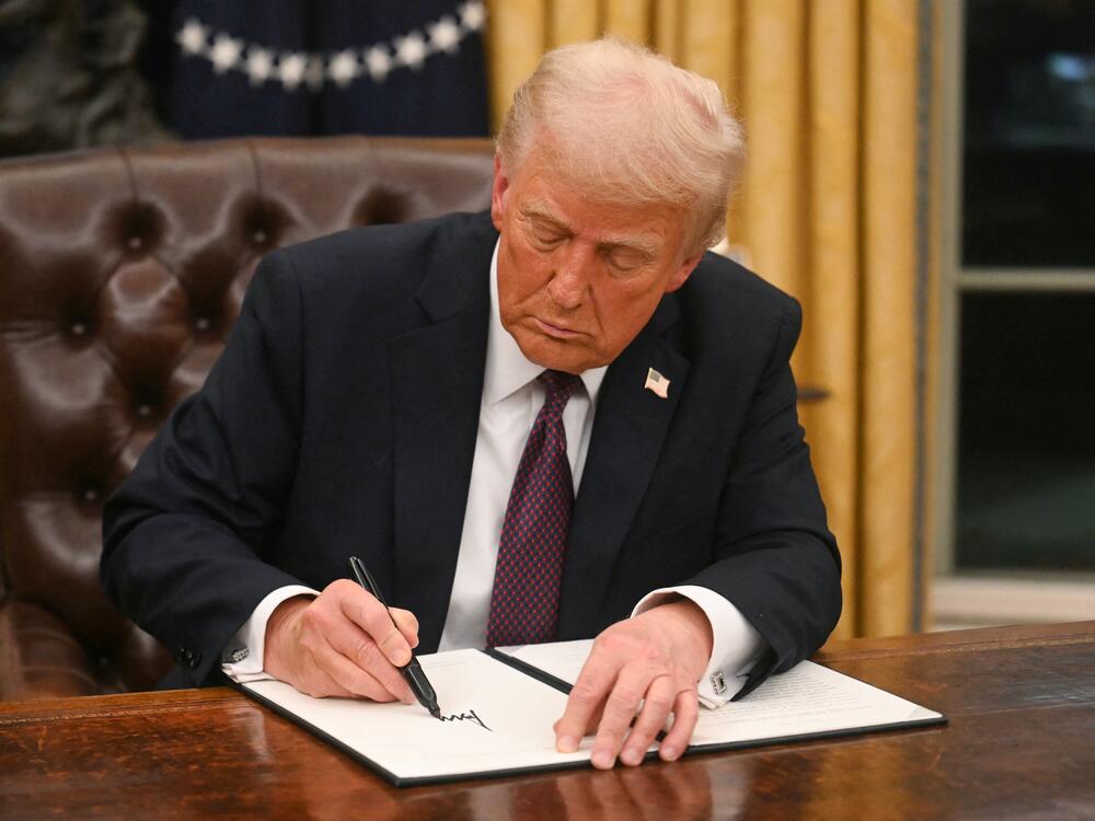 President Trump signs an executive order in the Oval Office on Inauguration Day.