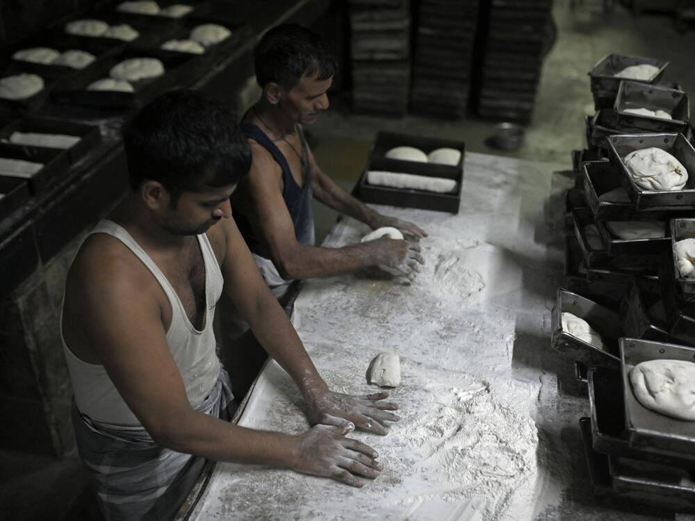 Bakers at the Yazdani Bakery in Mumbai knead trays of dough.