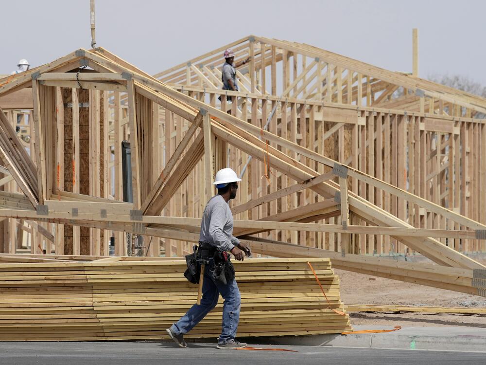Homebuilding has slowed as Americans face economic uncertainty and high mortgage rates. Here, construction workers install a lumber roof on a new home last month in Laveen, Ariz.