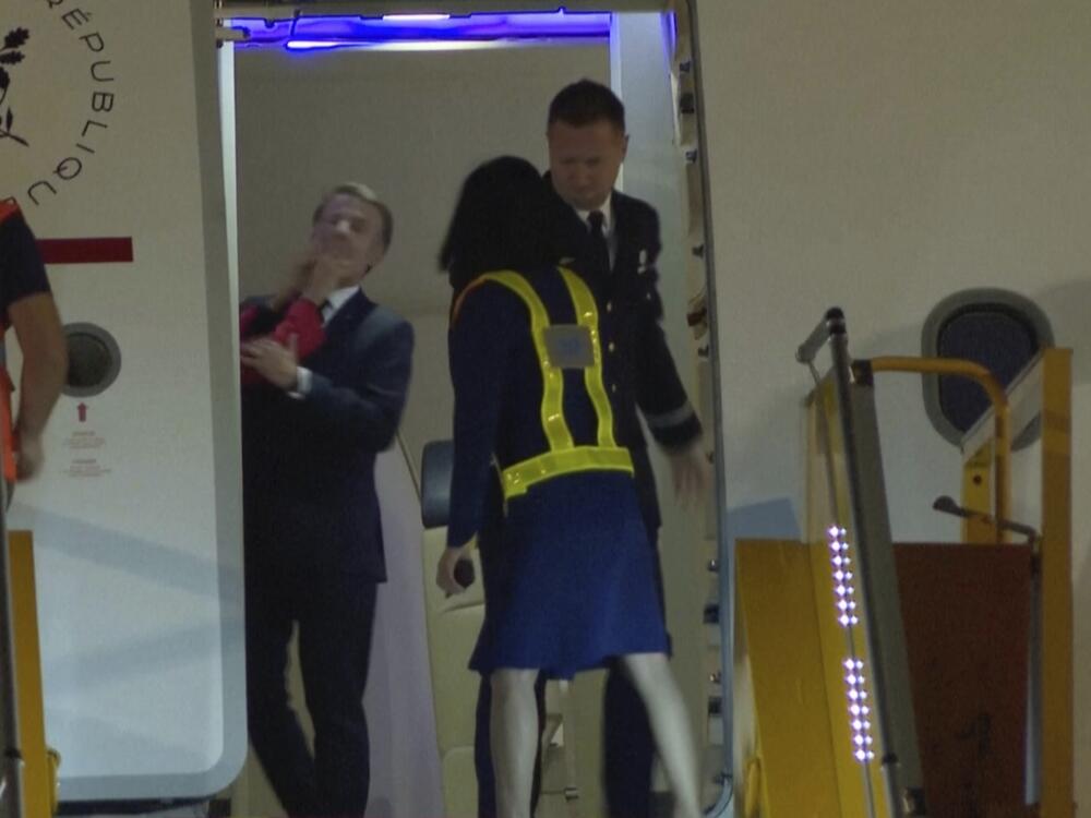 In a grab taken from video, France's President Emmanuel Macron is shoved while preparing to disembark a plane in Hanoi, Vietnam on Sunday.