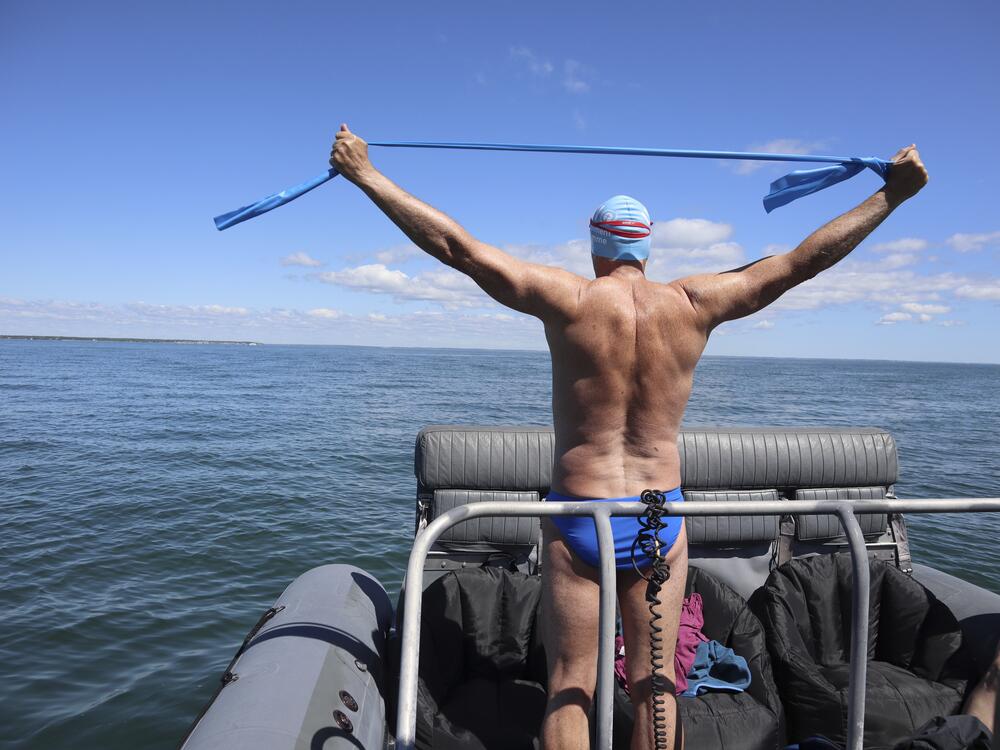 British South African endurance swimmer Lewis Pugh stretches before entering the water to complete his 12-day 62-mile swim around the island of Martha's Vineyard, Mass., ahead of the 50th anniversary of the first blockbuster film 