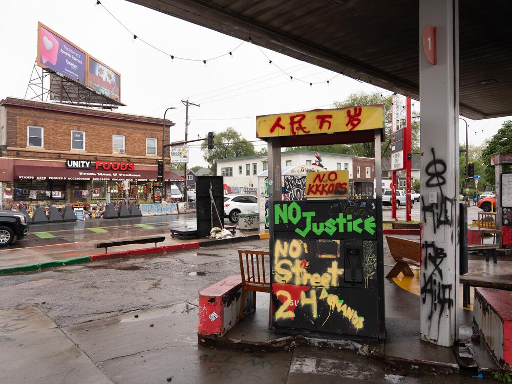 Graffiti condemning the police and demanding racial justice cover defunct gas pumps at George Floyd Square.