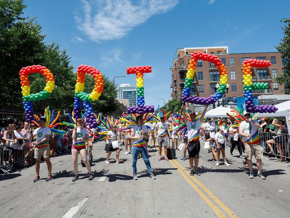 Participants carry balloons spelling out 