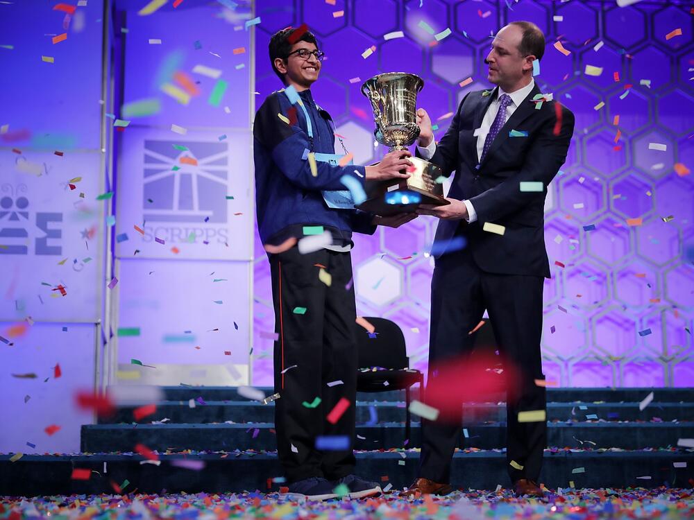 Karthik Nemmani (L) poses with the championship trophy and E.W. Scripps Company CEO Adam Symson after Nemmani correctly spelled the word 'koinonia' to win the 91st Scripps National Spelling Bee at the Gaylord National Resort and Convention Center May 31, 2018 in National Harbor, Maryland.