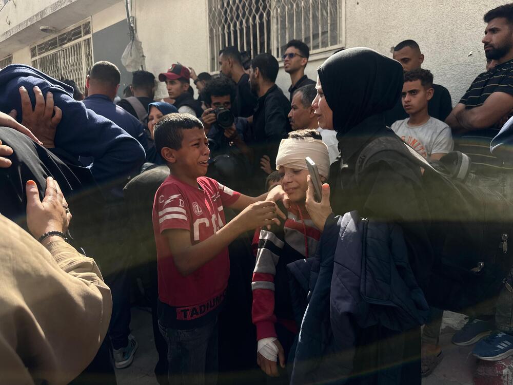 People embrace in the aftermath of the Gaza City School airstrike on May 27, 2025.