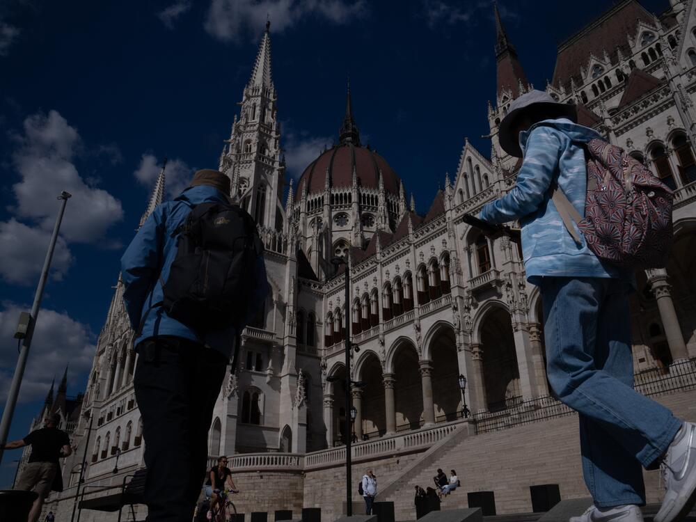 People walk past Hungary's parliament building in Budapest in May.