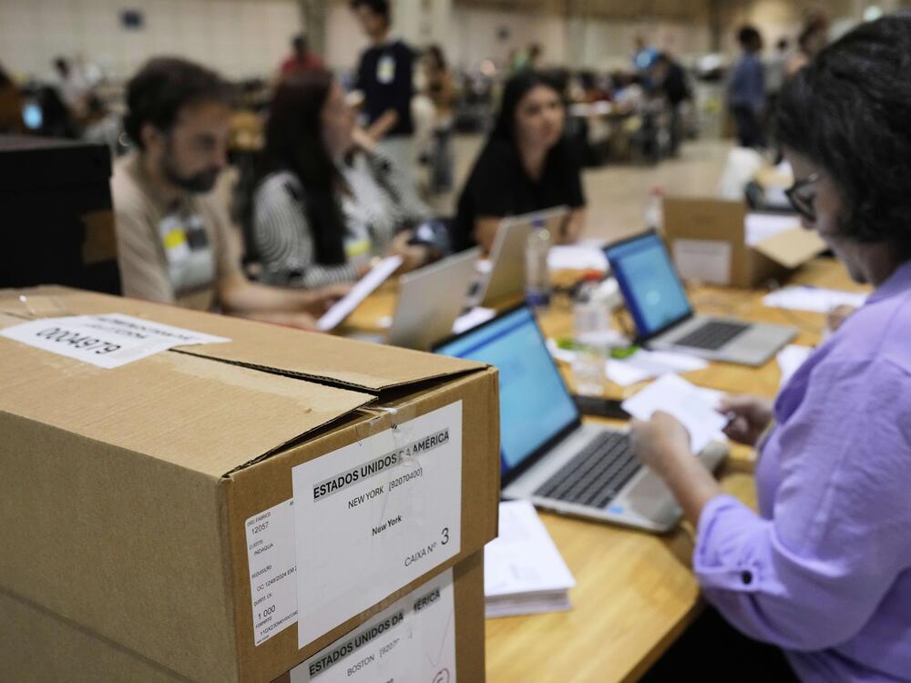 Boxes which arrived from New York and Boston containing votes for Portugal's May 18 general election are stacked on a desk where volunteers are registering them on the final day of counting of ballots from voters who live abroad, in Lisbon on Wednesday.