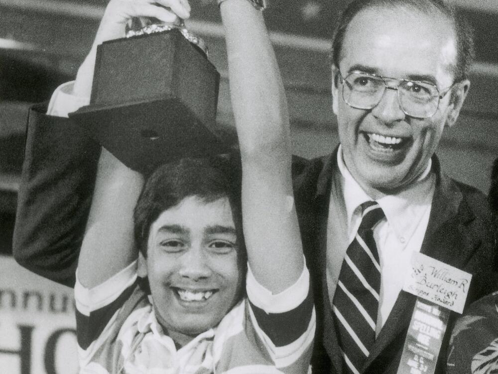 Balu Natarajan, an 8th grade student at Jefferson Junior High School in Woodbridge, Ill., holds his trophy with the aid of William R. Burleigh, vice president of Scripps Howard Newspapers, sponsor of the National Spelling Bee, after he won the competition in Washington, on June 6, 1985.