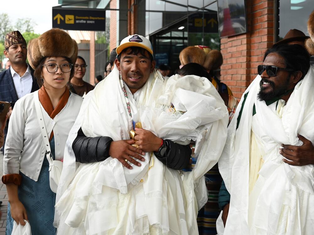 Nepali climber Tashi Gyalzen Sherpa, center, arrives at Tribhuvan International Airport in Kathmandu, Nepal, on Tuesday, after he made a record-breaking four summits of Everest in 15 days.