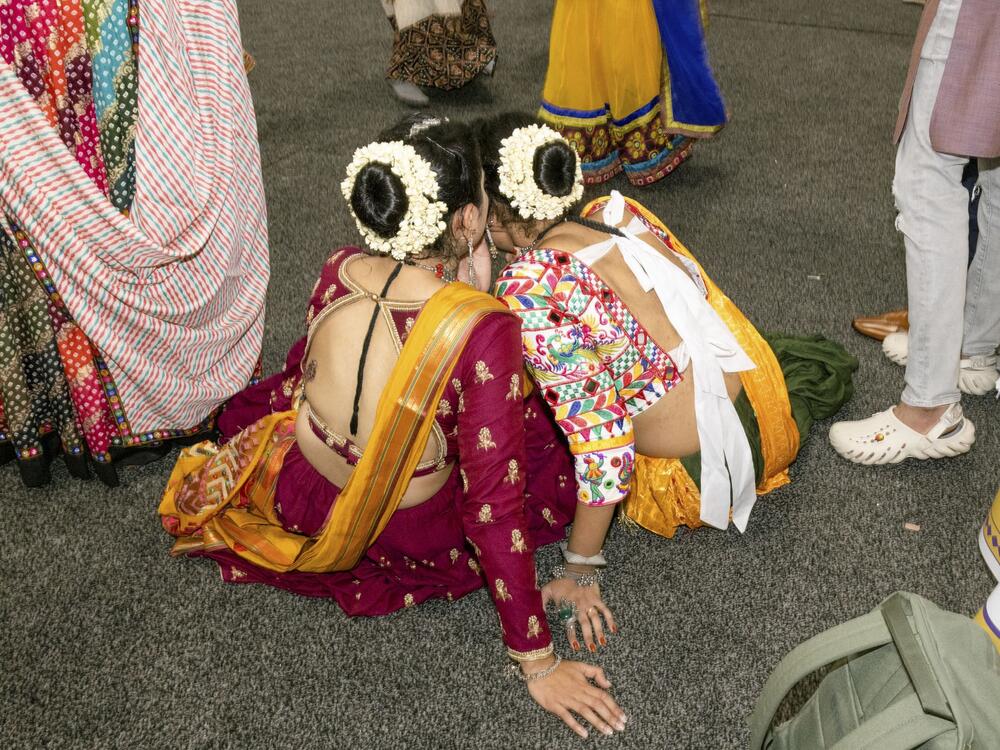 Two girls take a break from dancing at a garba at the New Jersey Convention and Exposition Center in Edison, N.J., on Sept. 28, 2024.