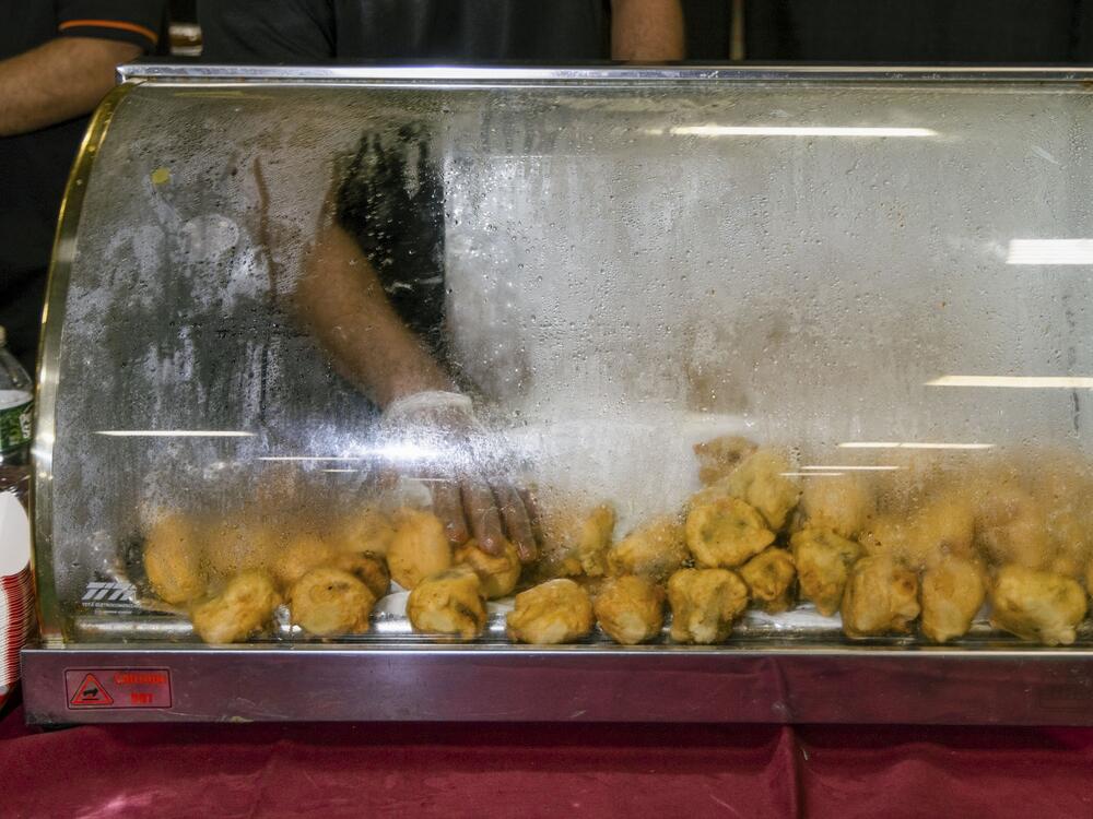 One of the many vendors present at the garba at the New Jersey Convention and Exposition Center on Oct. 4, 2024, reaches for a samosa, a popular South Asian snack food.