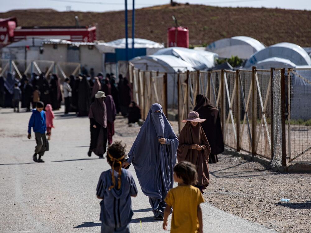 Women and children walk at Camp Roj, where relatives of people suspected of belonging to the Islamic State group are held, in Syria's northeastern Hasakah province in October 2023.