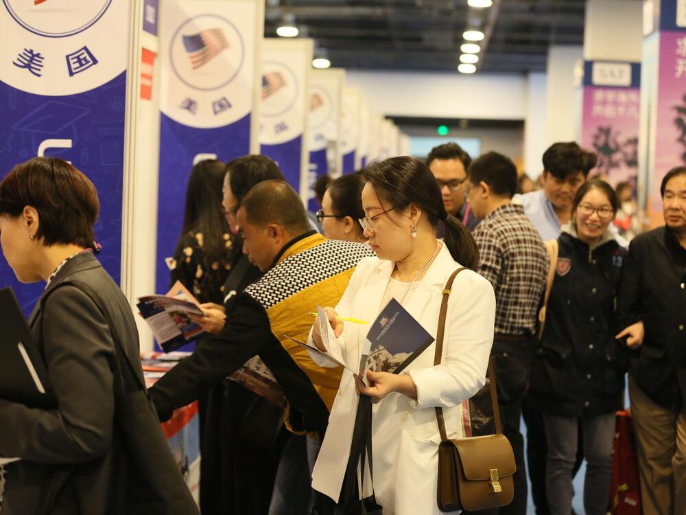 Chinese visitors talk with education consultants at a booth of the United States during an expo in Beijing, China, October 20, 2018.