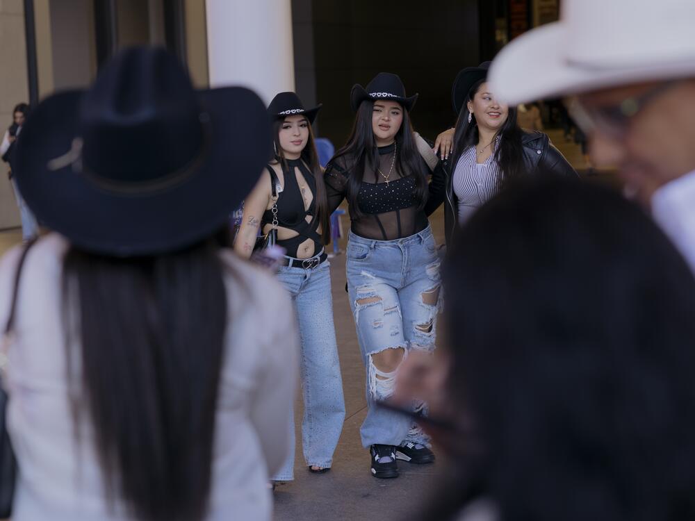 A group poses for a photo as Los Tigres del Norte's fans navigate the bustling block outside of Madison Square Garden before the start of the show.