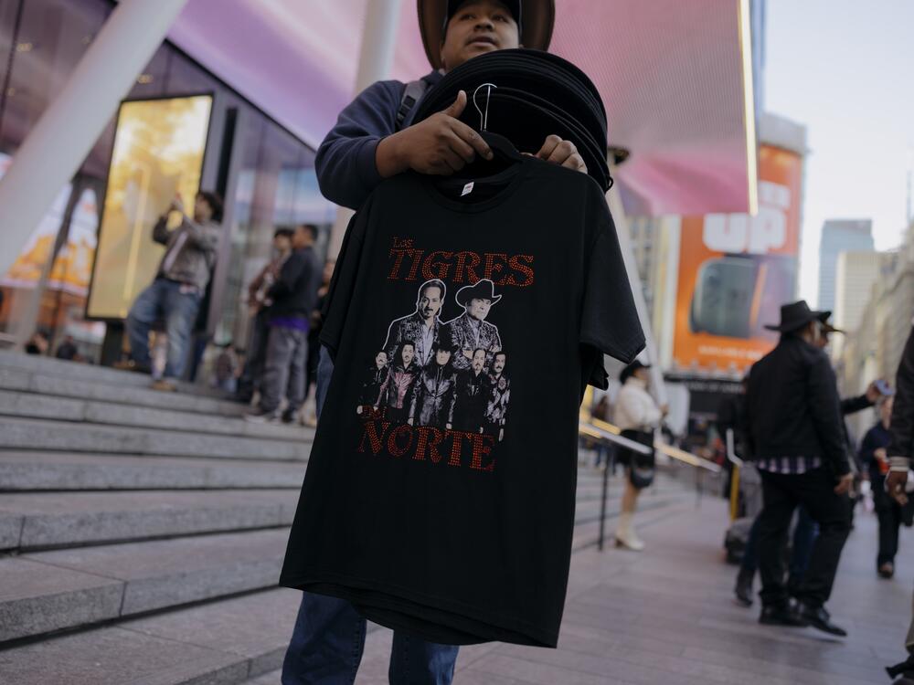 Vendors sell shirts, hats and drinks as Los Tigres del Norte's fans navigate the bustling block outside of Madison Square Garden before the start of the show.