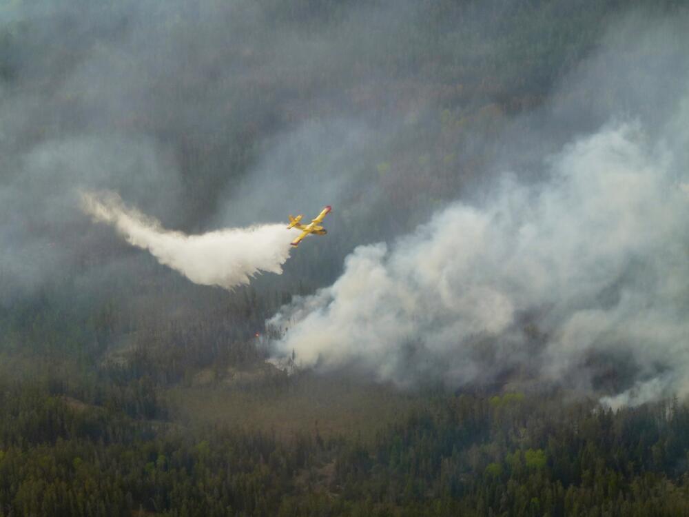 A water bomber aircraft battles a wildfire in southeast Manitoba as shown in this handout photo provided by the Manitoba government on Tuesday.