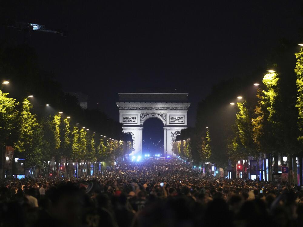 Soccer fans celebrate PSG's victory on the Champs-Elysees avenue, with the Arc de Triomphe in background, after the Champions League final soccer match between Paris Saint-Germain and Inter Milan, Sunday, June 1, 2025 in Paris.