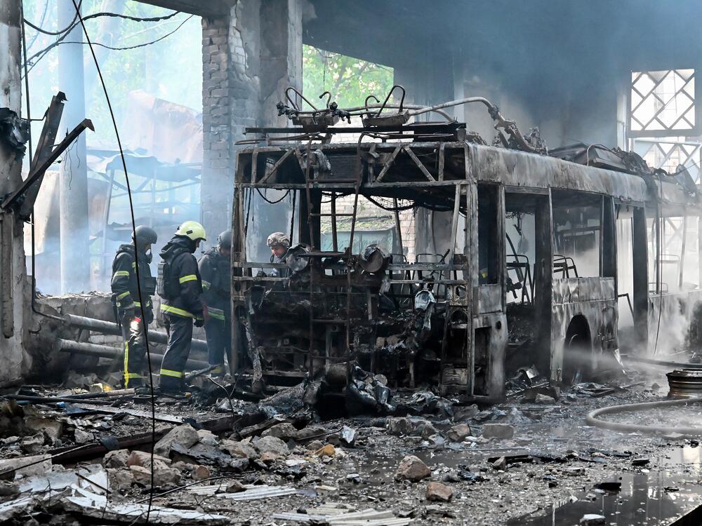 Ukrainian rescuers work to extinguish a fire in a trolleybus depot following a drone strike in Kharkiv on Friday, amid the Russian invasion of Ukraine.