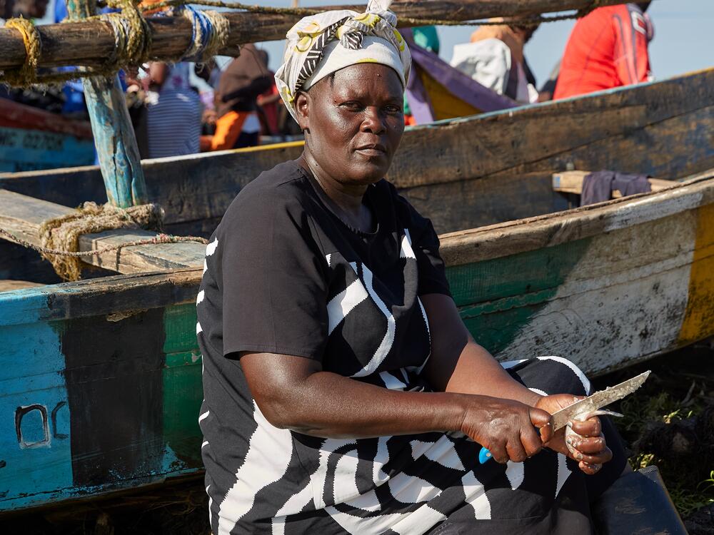Rebbeccah Atieno, a No Sex For Fish member, scales and guts the fish she bought from fellow member Alice Akinyi at Nduru Beach, getting them ready to sell.