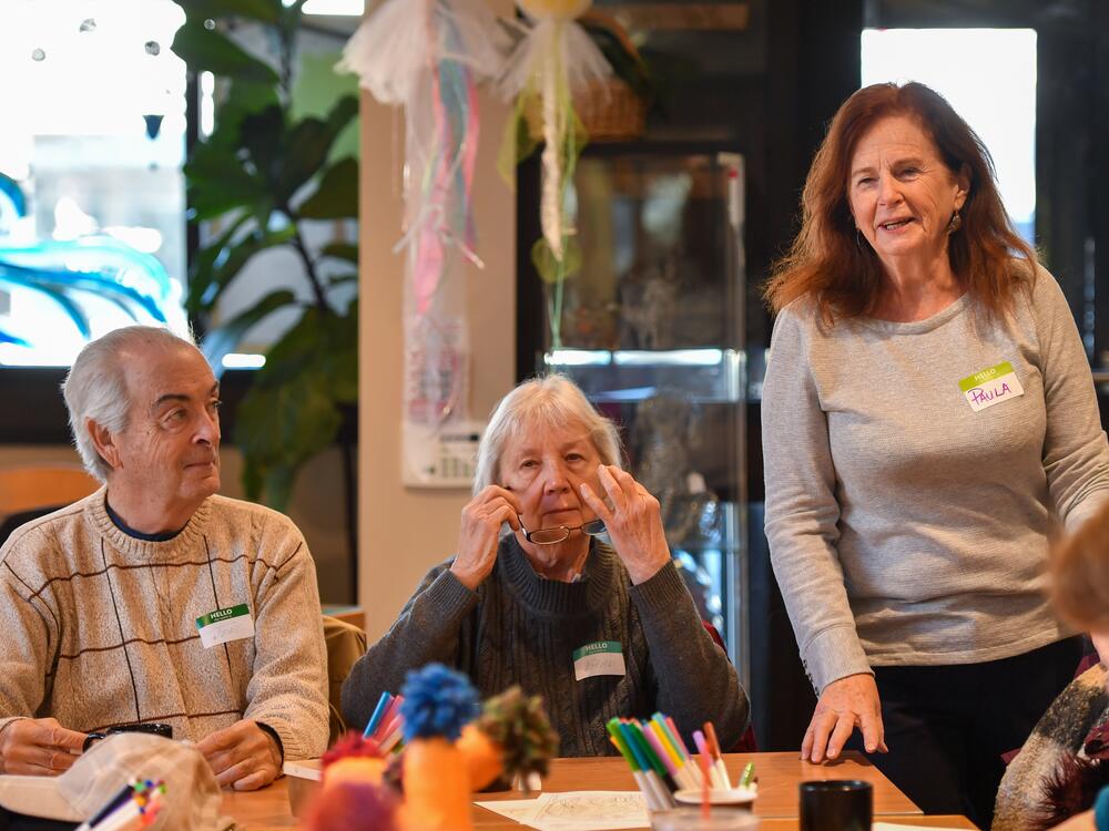Paula Baille talks with guests at the Gathering Place in Clarks Summit during the Friday memory cafe, while Joe and Barb Edwards listen.
