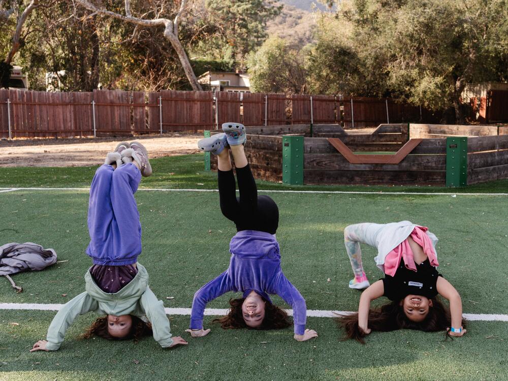 Campers do handstands on the soccer field at Project:Camp in Glendale, Calif.