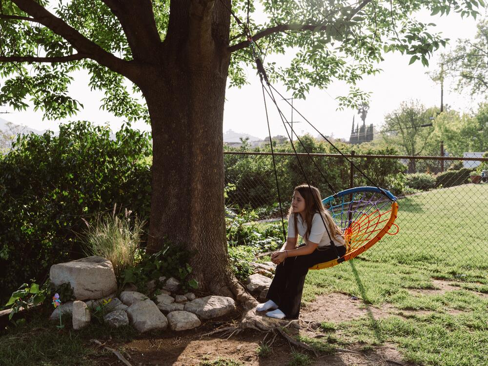 Emory Stumme takes a moment to reflect on a tree swing outside of her new home in La Crescenta-Montrose, Calif.