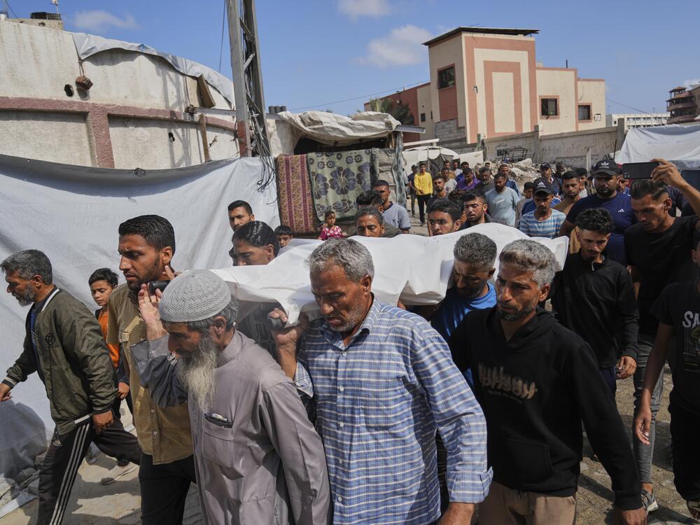 Palestinians carry the body of Reem Al-Akhras who was killed while heading to a Gaza aid hub, during her funeral in Khan Younis, southern Gaza Strip, Tuesday.