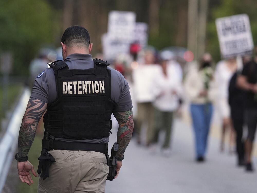 A Krome Detention Center officer patrols as people hold a vigil on May 24 to recognize those who have died in U.S. Immigration and Customs Enforcement custody as well as those affected by mass deportations, outside Krome Detention Center in Miami.