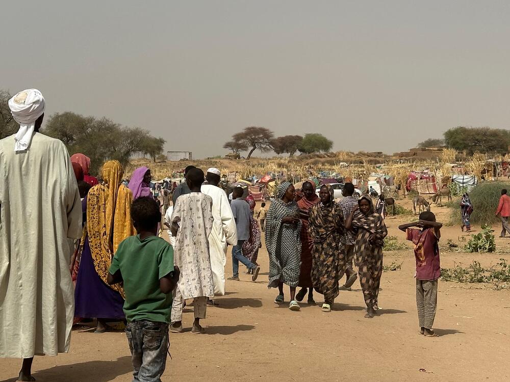 People who fled violence in Darfur walk through a makeshift encampment in the western Darfur region on April 13, 2025.