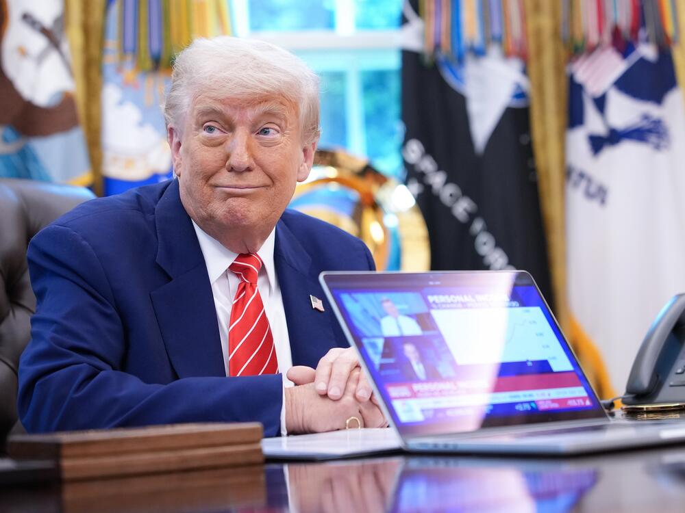 U.S. President Donald Trump, joined by Tesla CEO Elon Musk, shows a news video from a laptop in the Oval Office of the White House on May 30, 2025 in Washington, DC.