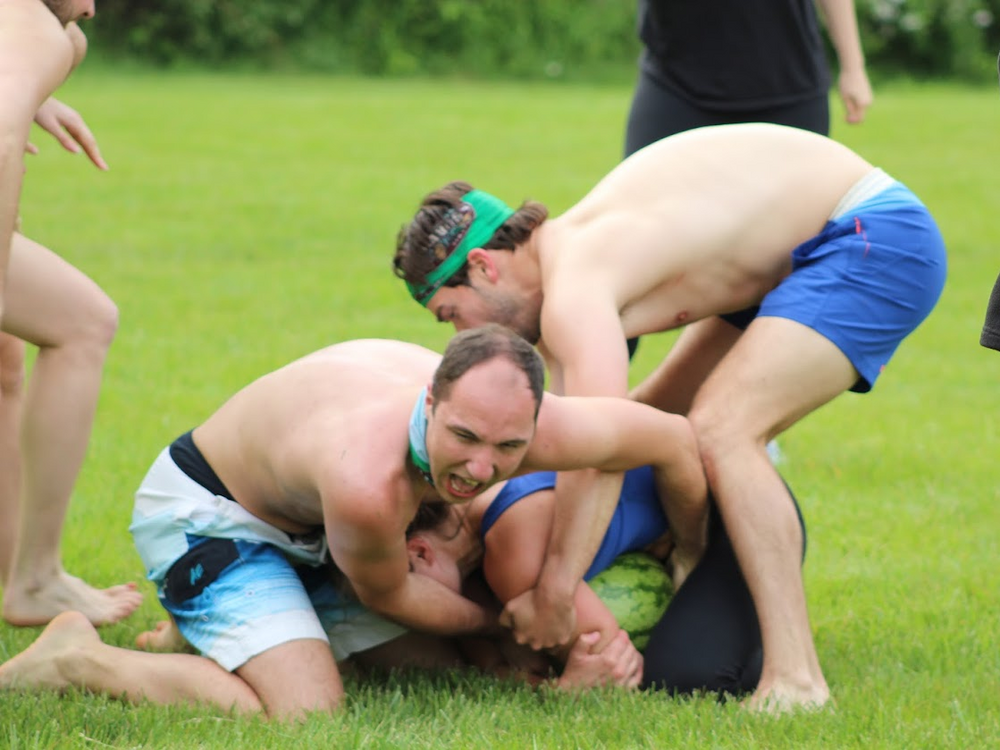 Ian Scaduto (L) and Justin Grant (R) try to wrestle the Crisco-covered watermelon out of Juliana McCormick's death grip. They are not successful.