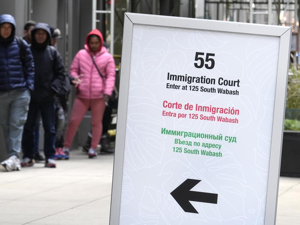 People wait in a cue before being led into a downtown Chicago building where an immigration court presides in November 2024 in Chicago.