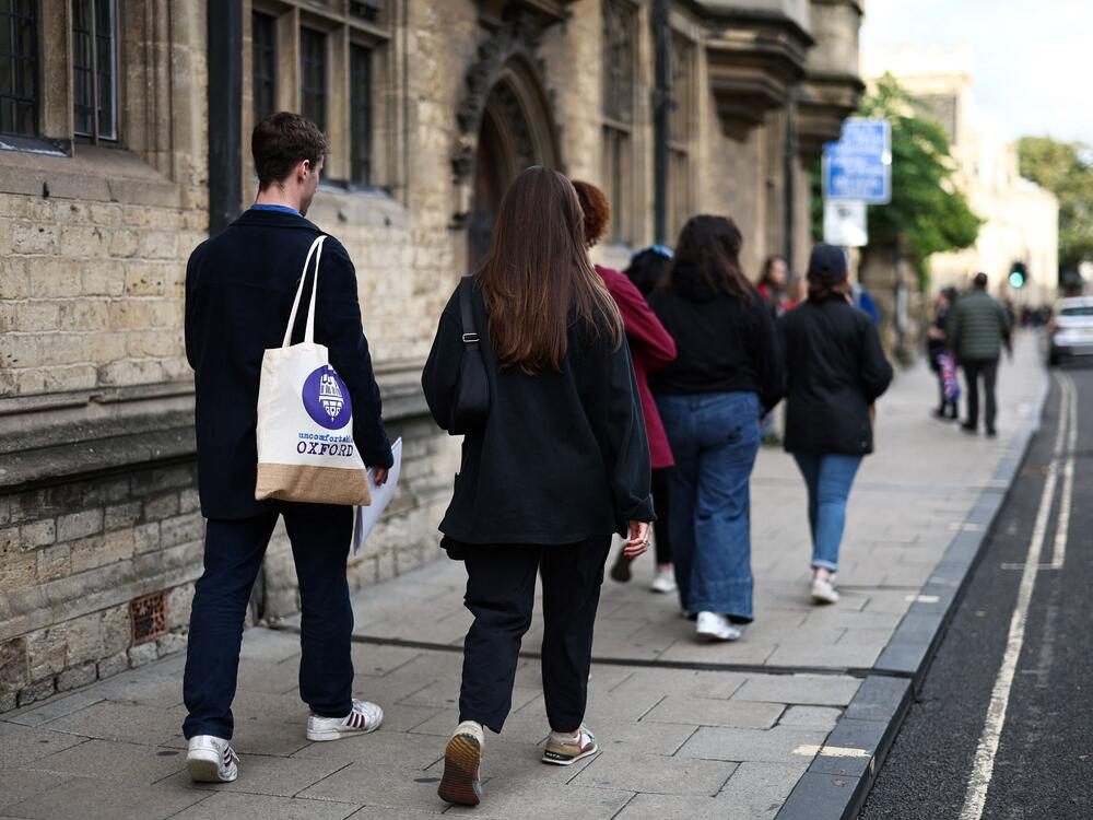 A tour guide walks with a group of people attending an Uncomfortable Oxford Tour, in Oxford, on Oct. 20, 2023.