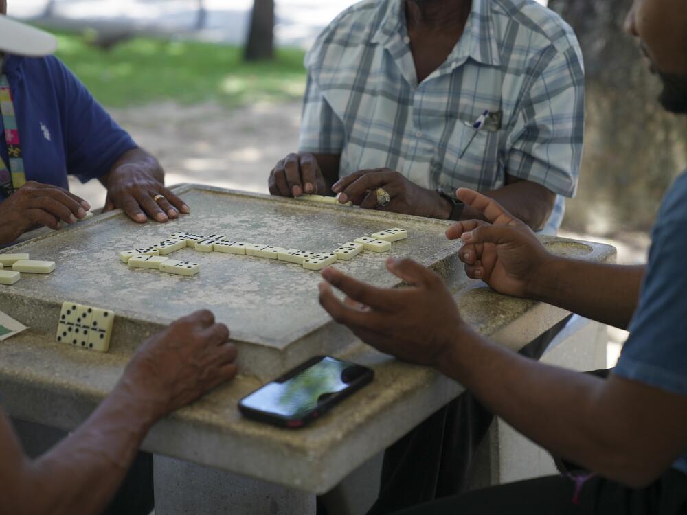A group of men play dominoes at the Antonio R. Barceló Plaza in Barrio Obrero, the heart of the Dominican community in Puerto Rico.