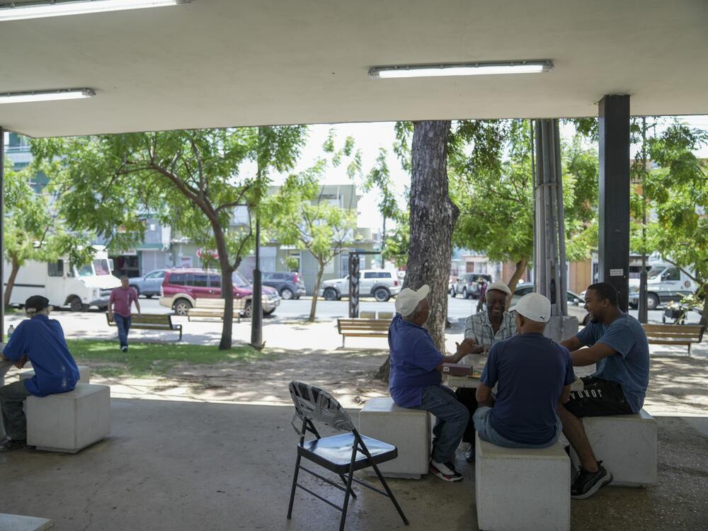 A group of men play dominoes at the Antonio R. Barceló Plaza in Barrio Obrero, the heart of the Dominican community in Puerto Rico. The area has been empty after the first immigration raid in Barrio Obrero in January 2025.