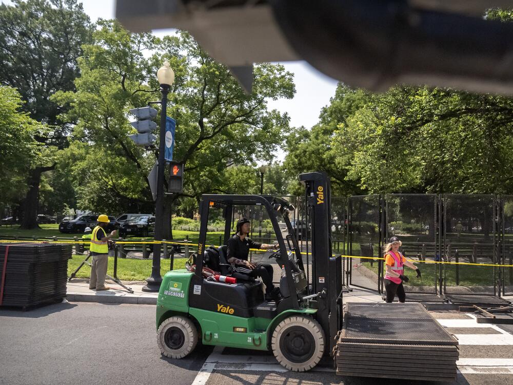 Workers put up fencing around Washington, D.C.'s Dupont Circle on Friday. In a reversal Saturday morning, the fencing was being taken down.