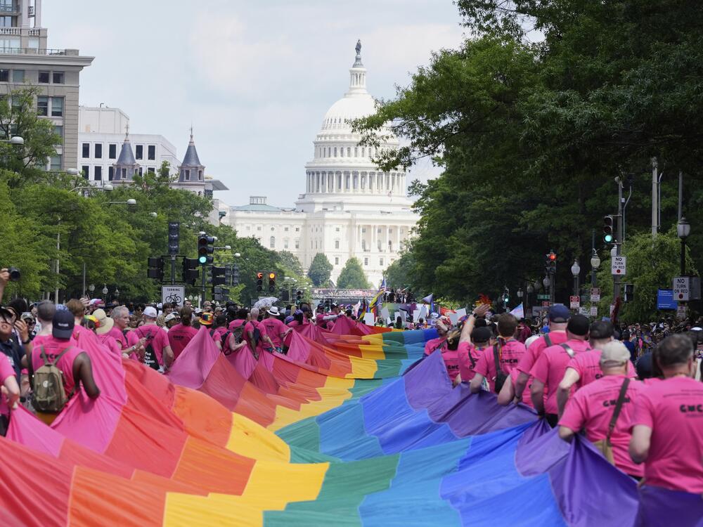 Participants carry a large pride flag during the WorldPride parade with the U.S. Capitol in the background on Saturday in Washington.