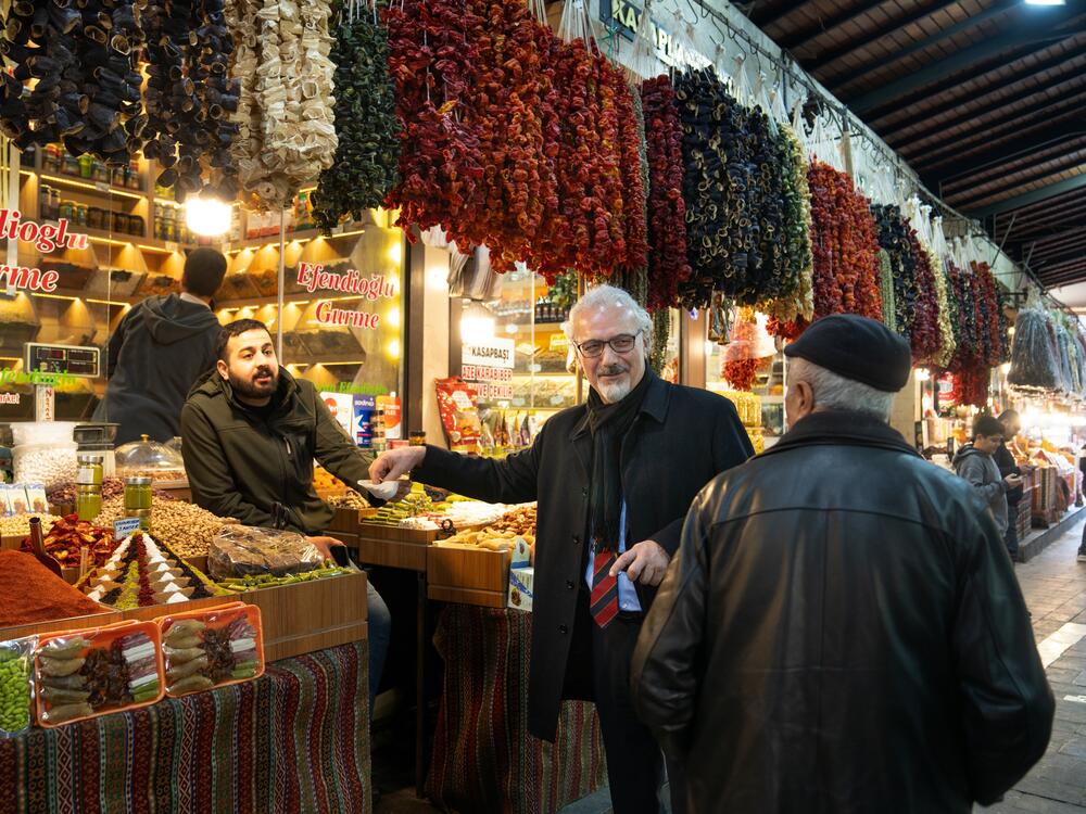 Mustafa Bayram (center), a professor of food engineering at Gaziantep University, walks through the Elmaci bazaar in Gaziantep, looking at and talking about the different foods and ingredients for sale.