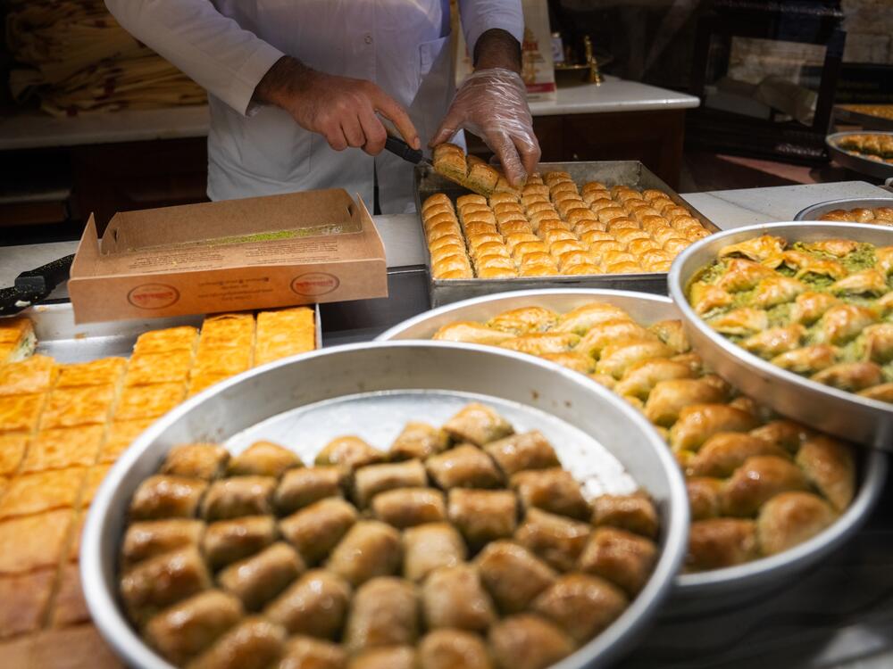 Different types of baklava are on display and being packaged at Gulluoglu, a shop in Gaziantep, Turkey. The city has many shops dedicated to the sweet pastry.