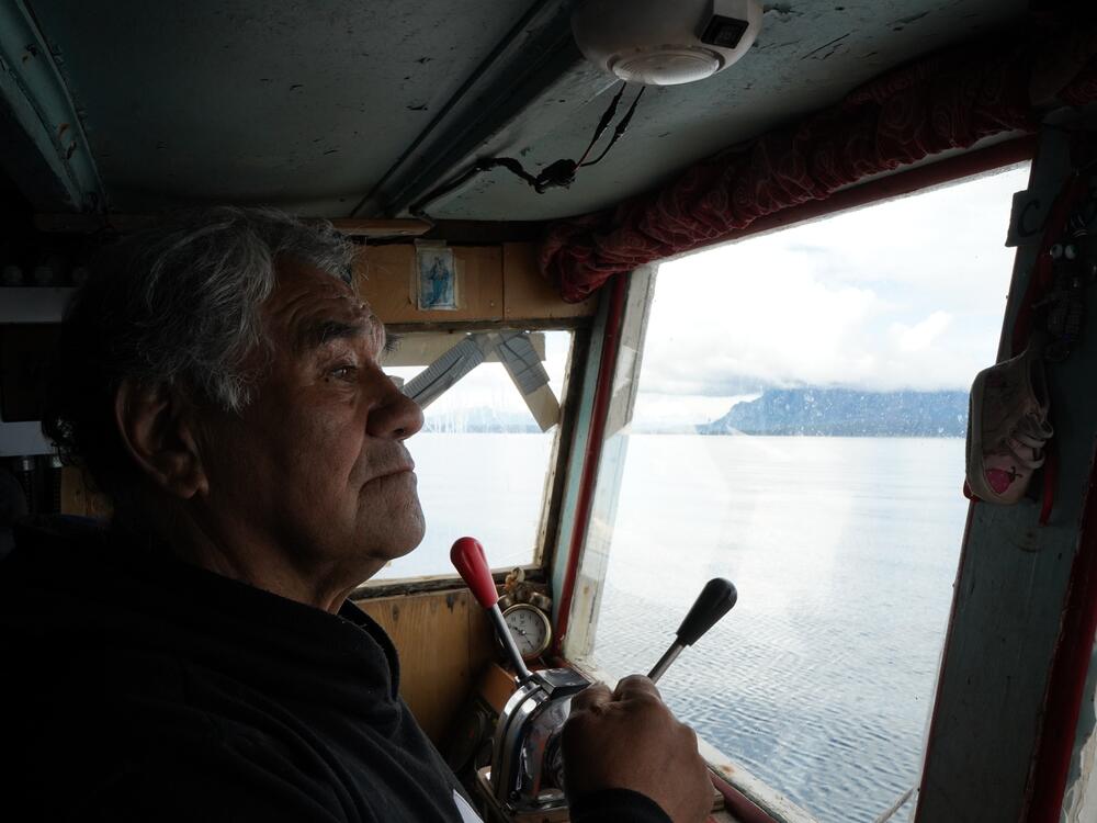 Reinaldo Caro surveys the shoreline of the Almirante Montt Gulf from the cabin of the Calipso on his way through the fjords toward the Kirke Channel.