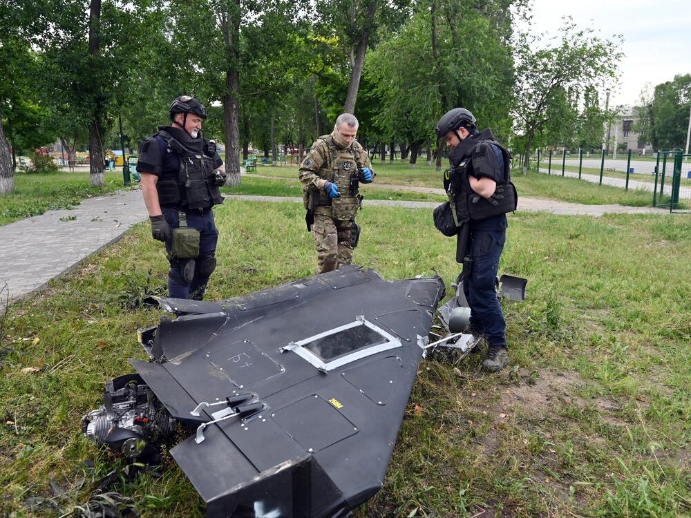 Ukrainian explosives experts and police officers examine parts of a Shahed 136 military drone following an air-attack in Kharkiv on June 4, 2025, amid the Russian invasion of Ukraine. (Photo by SERGEY BOBOK / AFP) (Photo by SERGEY BOBOK/AFP via Getty Images)