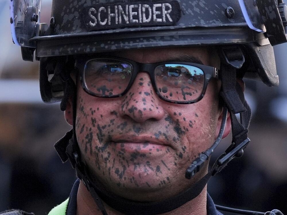A police officer's face is covered in pepper spray outside the Metropolitan Detention Center of downtown Los Angeles.