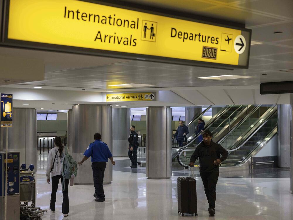 Travelers pass through Newark Liberty International Airport's international terminal after President Trump's new travel ban took effect on Monday.