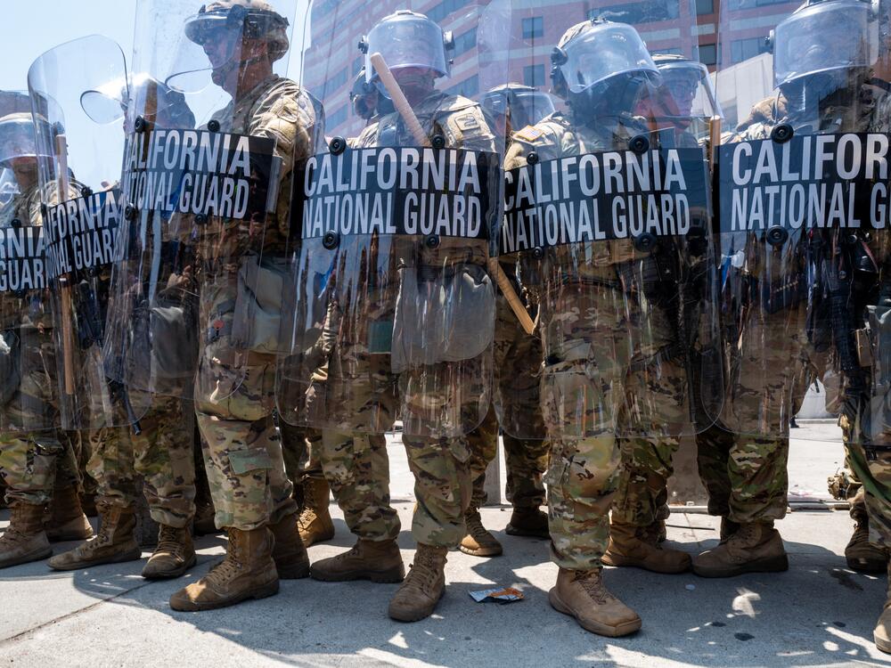 The National Guard, police and protesters stand off outside of a downtown jail in Los Angeles following two days of clashes with police during a series of immigration raids.