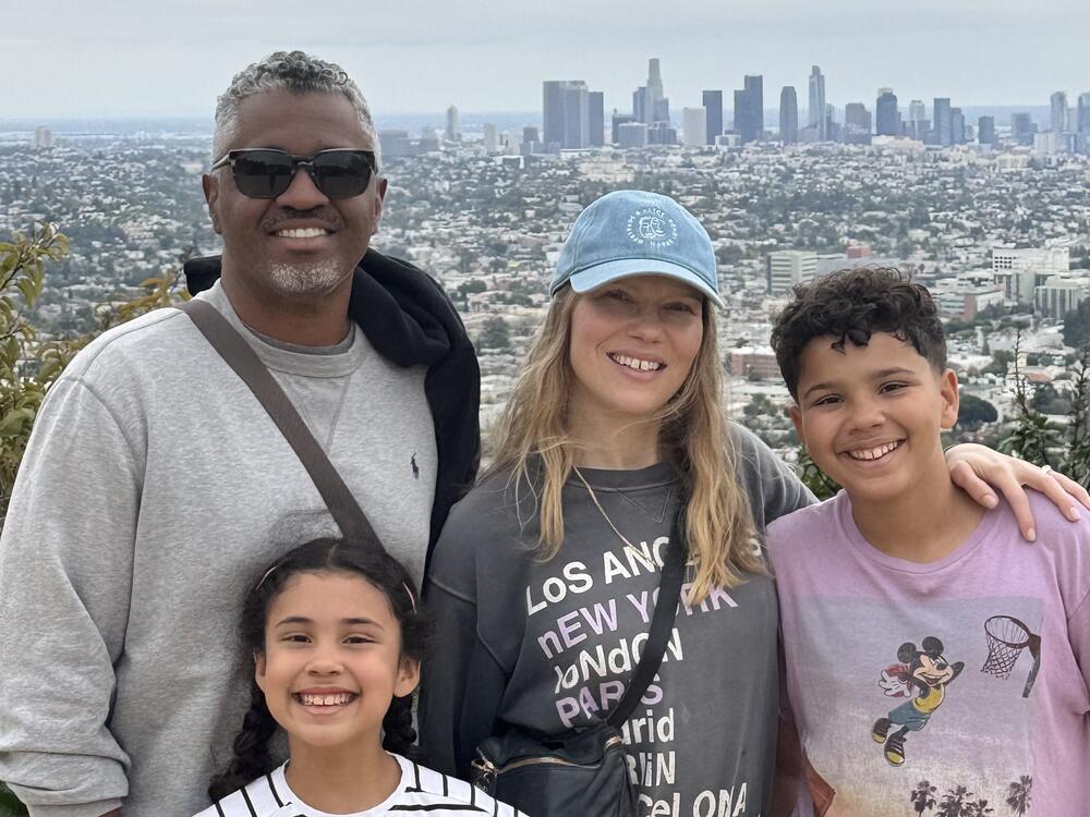 Stacey and Anna Manley with their children as they smile for the camera in front of a stellar view.