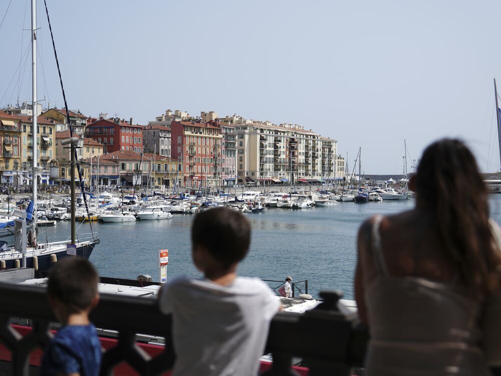 A family looks out at the boats on the water at Port Lympia where the U.N. Ocean Conference is taking place in Nice, France.