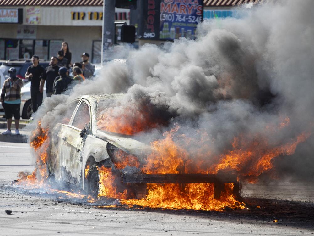 A car burns during a protest following federal immigration operations in the Compton neighborhood of Los Angeles on Saturday.